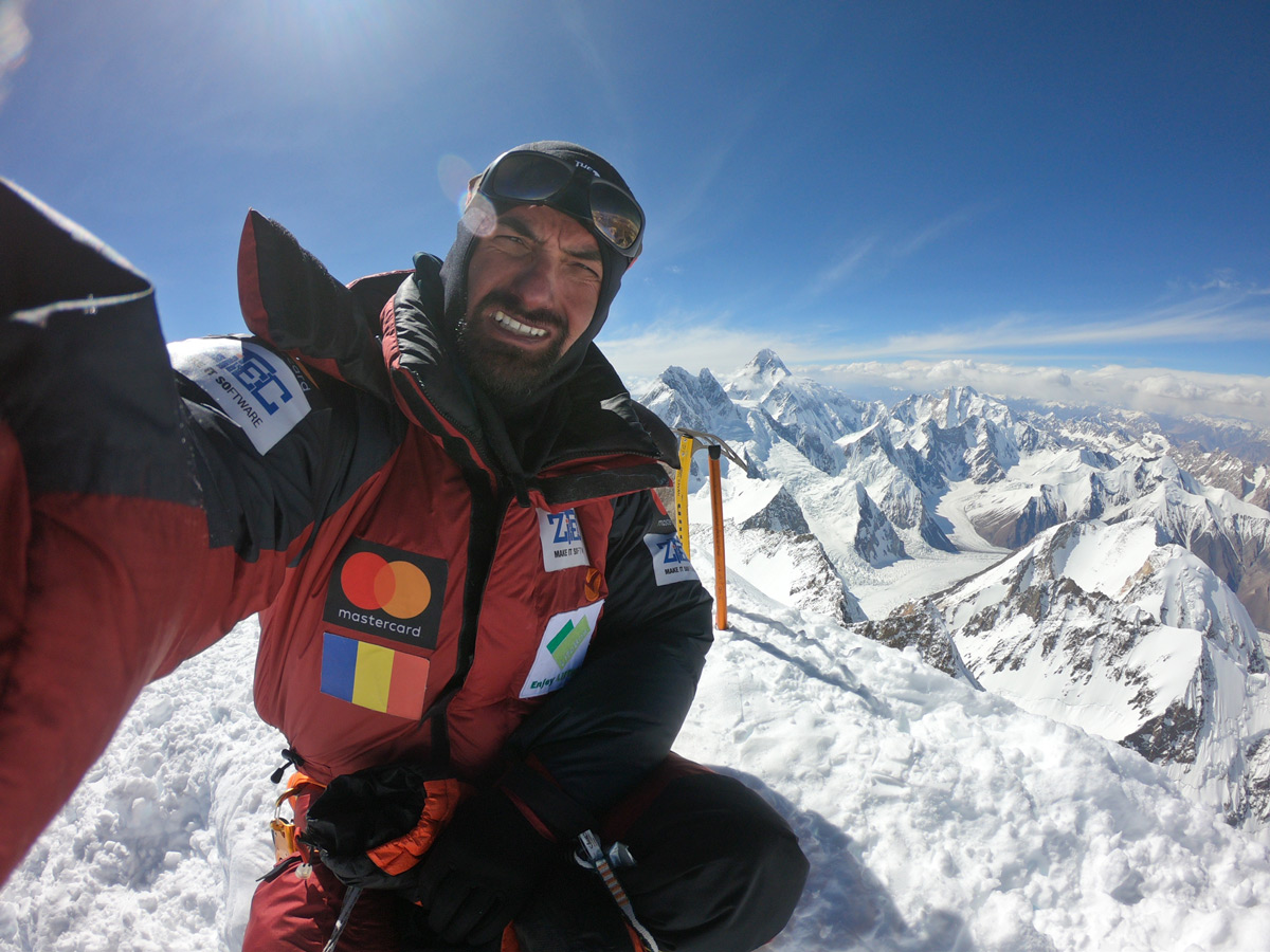 Caption Alex Gavan on the summit of Gashebrum 2 (8035m), july 2019, with Broad Peak (left, 8047m, which Alex summited back in 2014) and K2 the highest mountain visible in the background - Photo Alex Gavan